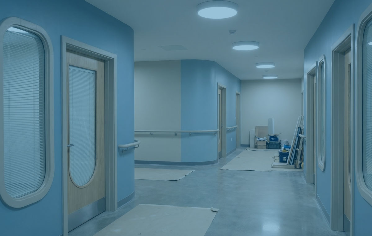 Mental health corridor with safe fixtures and vision panels in soft clinical light