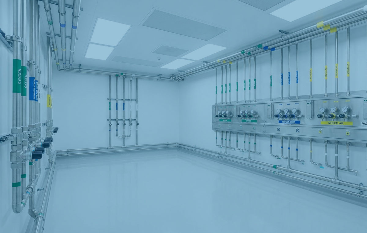 Clinical plant room with a medical gas manifold and labelled valves in bright white light