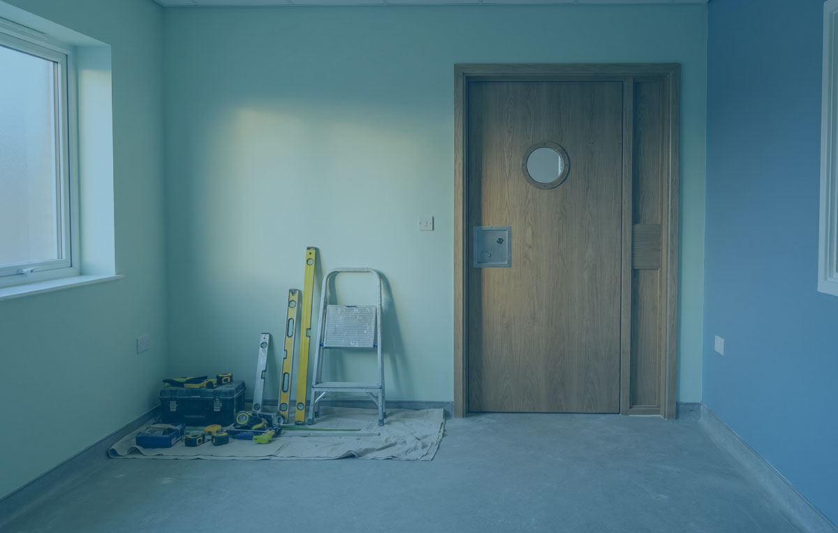 Seclusion room under construction with an anti ligature door set and observation window in warm daylight